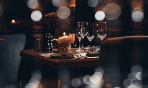 wine glasses and a candle in a warm lit restaurant